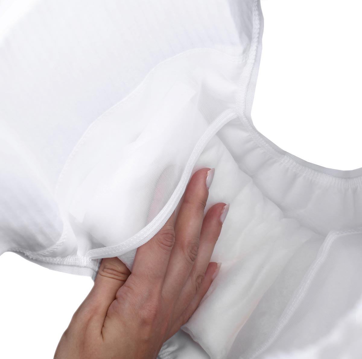 Eine Hand greift in eine weiße, weiche Textilfläche, die eine Innenseite mit Polsterung zeigt. Diese könnte Teil eines Inkontinenzproduktes sein, auf einem neutralen Hintergrund.