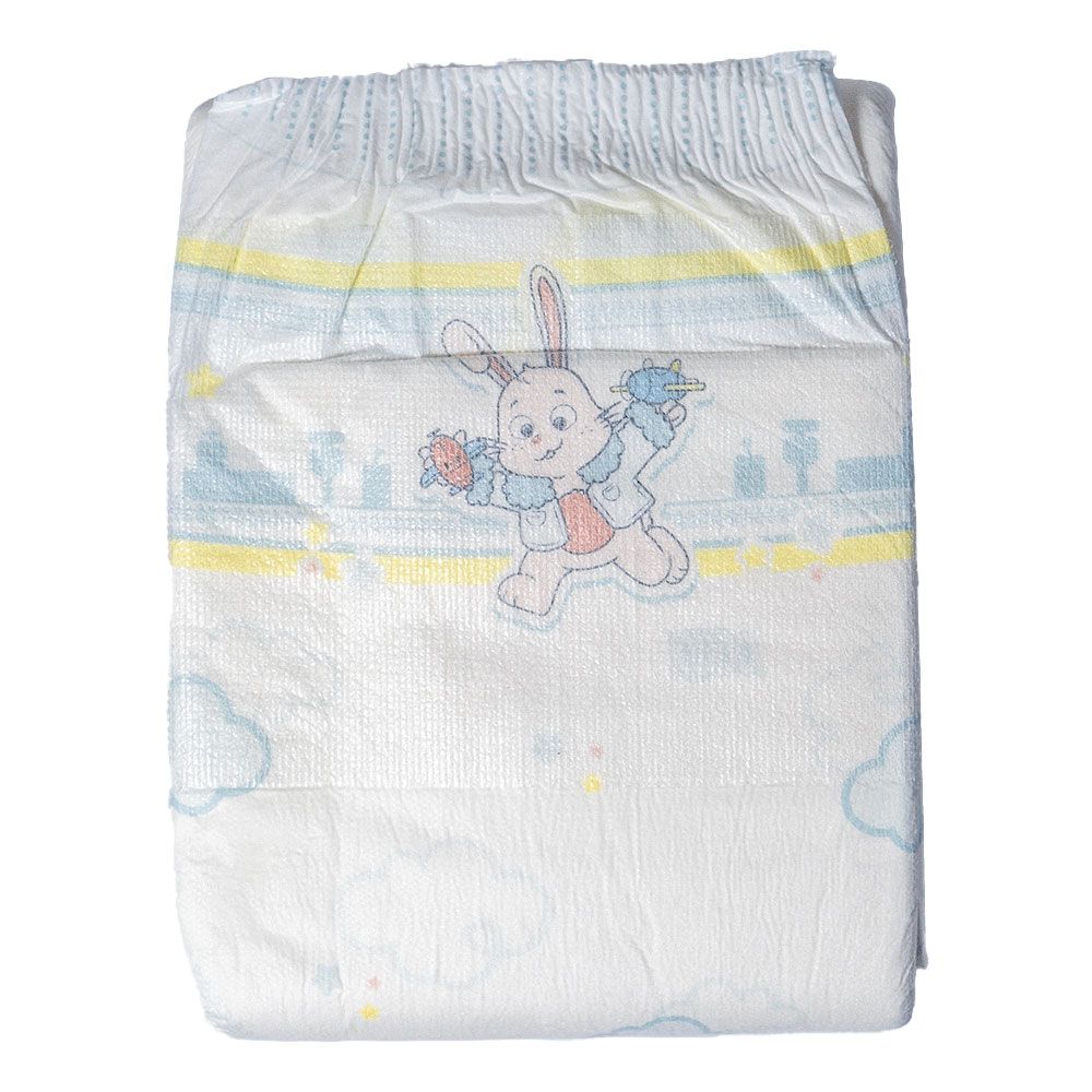 Ein Babywindel ist sichtbar, mit einem bunten Motiv eines Hasen, der mit Spielzeug spielt. Die Windel hat eine weiche Textur und ist in hellen Farben mit Wolken und einem bunten Muster gestaltet.