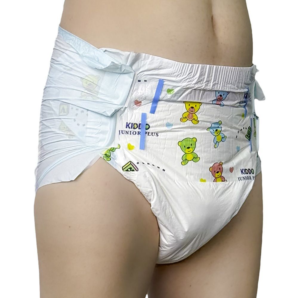 Hose mit bunten Bärchenmotiven, die an einer Körperseite befestigt ist. Sie wird an einer Person getragen und zeigt eine weiche, absorbierende Außenschicht.