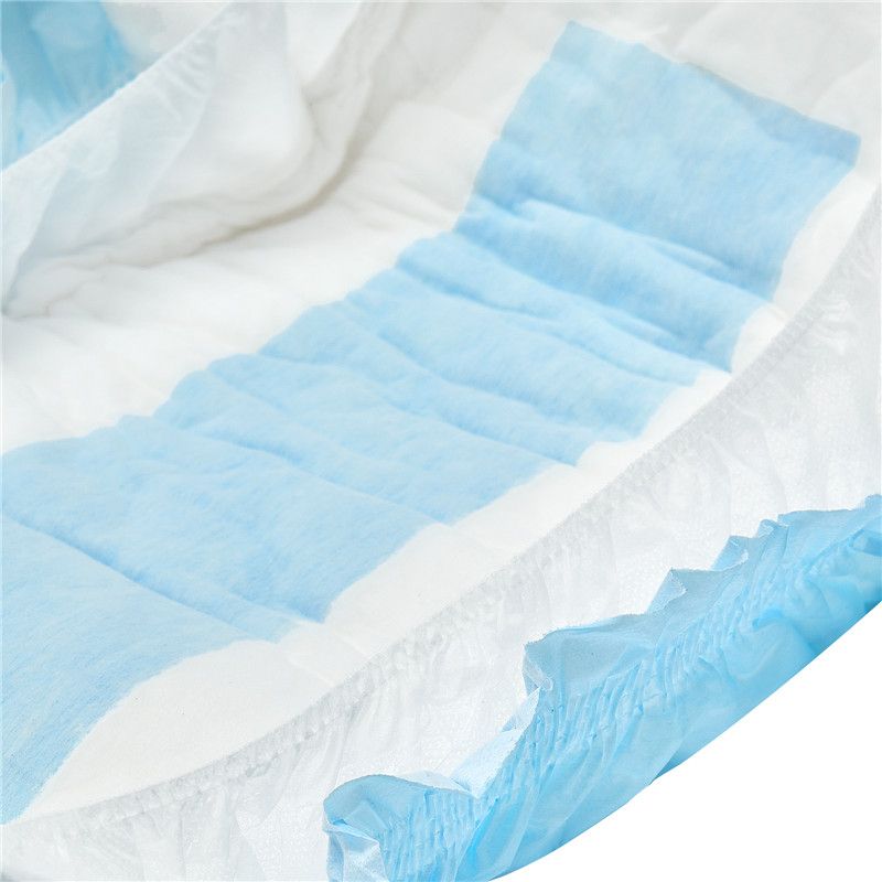 Ein Windelprodukt mit blauen und weißen Bereichen ist sichtbar. Die blauen Lagen sind weich und gewellt, während der Rand elastisch gestaltet ist. Der Hintergrund ist neutral und hell.